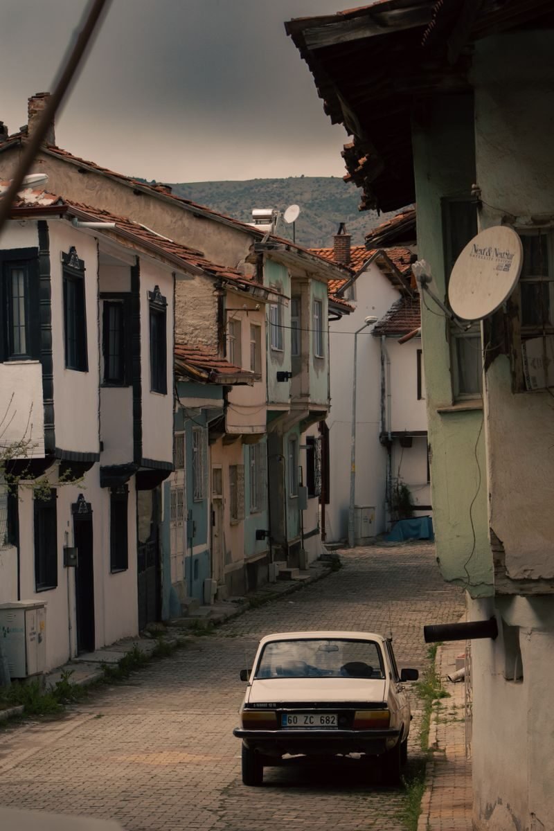 Vintage car on a quaint cobblestone street in historic Tokat, Turkey.