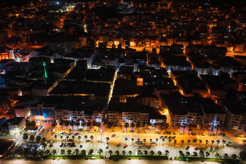 A stunning aerial view showcasing vibrant city streets illuminated at night with vivid lights.