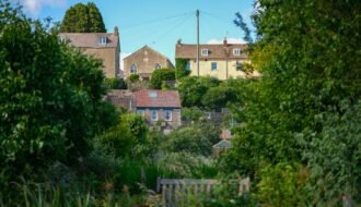 Scenic view of traditional houses set amidst lush greenery in Malmesbury, England.