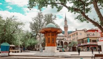 Charming town square with traditional architecture and mosque in a lively urban setting.