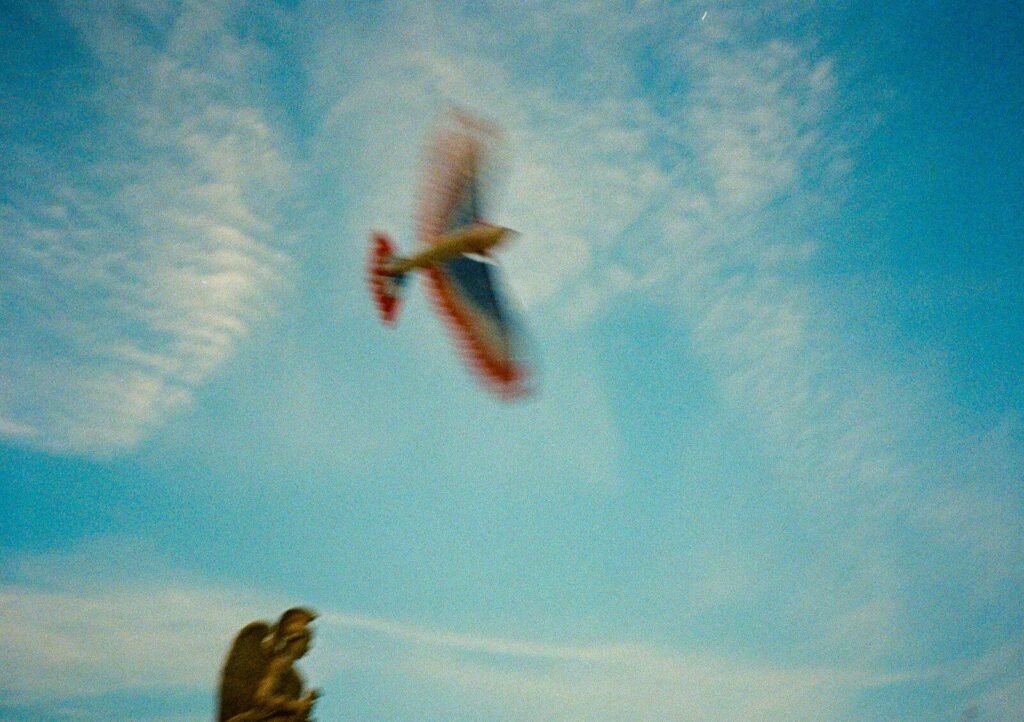 A small plane performs aerobatics in a blue sky.